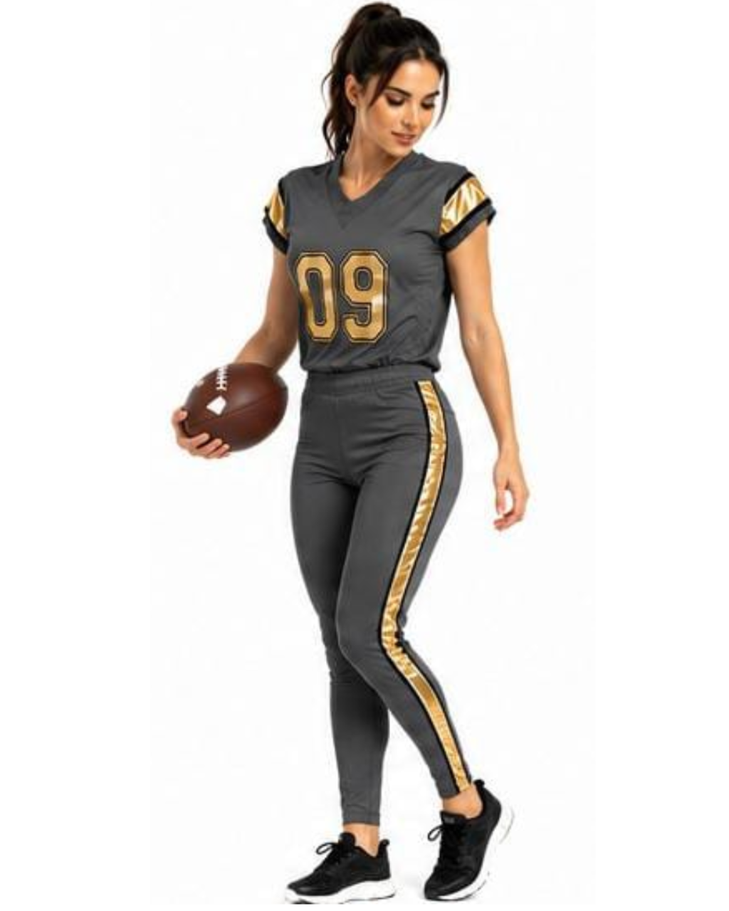 A woman modeling a dark gray football uniform set with gold trim and the number 09 on the chest, holding a brown football against a plain white background.