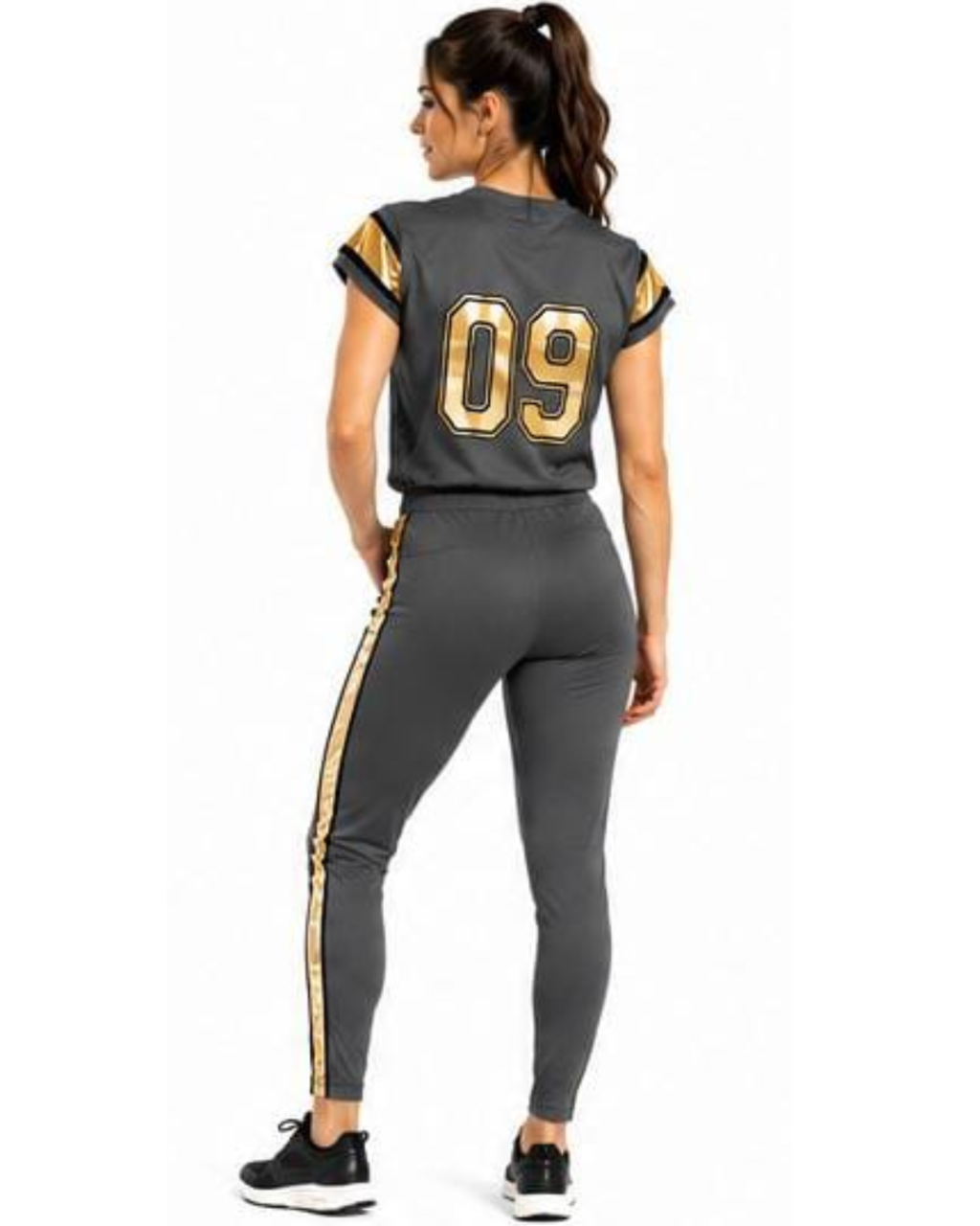 A woman shown from the back wearing a dark gray athletic two-piece set with gold accents, featuring a short-sleeve jersey with the number 09 on the back and matching leggings with a gold stripe down the side.