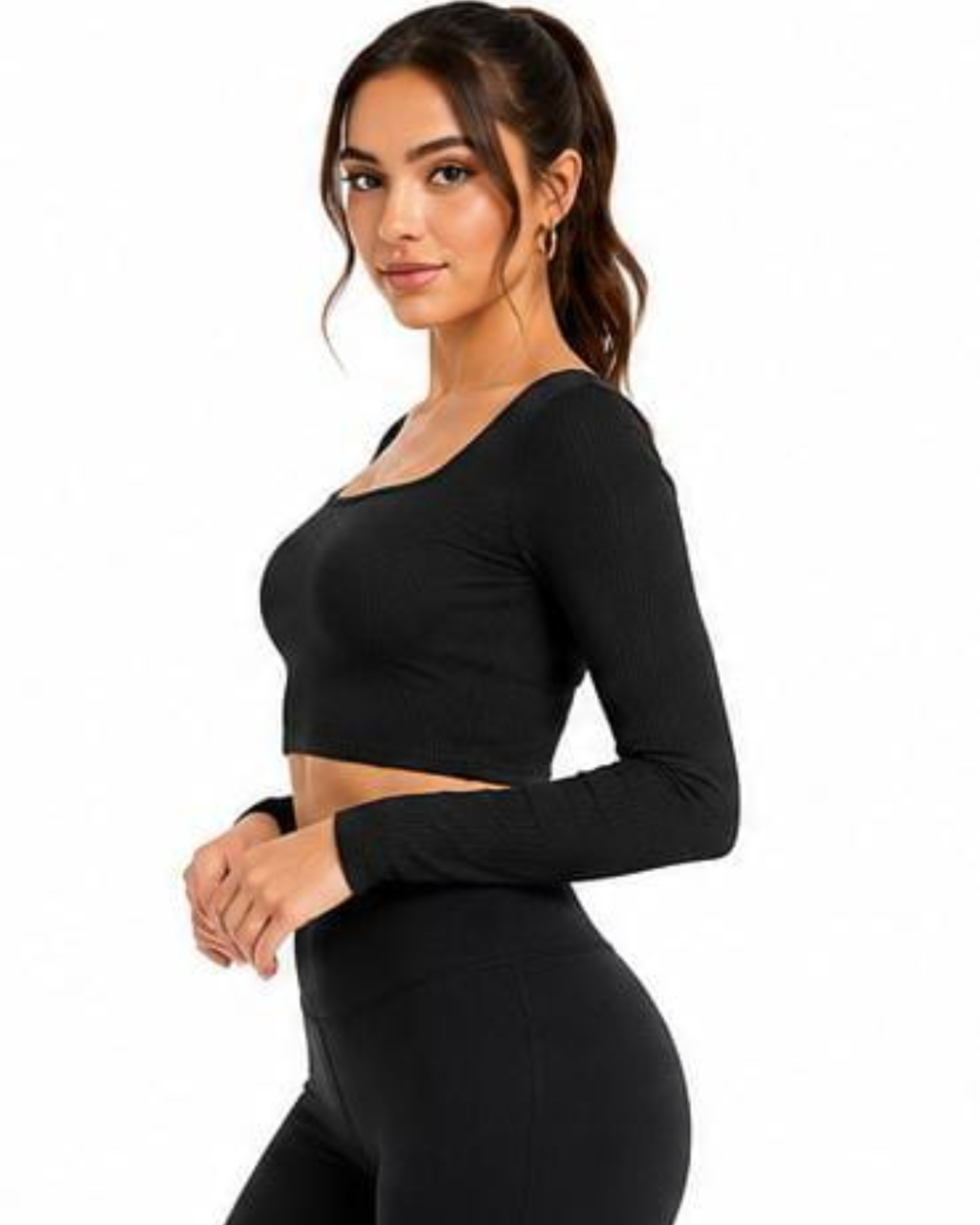 A woman modeling a black long-sleeve scoop-neck crop top and matching black leggings against a plain white background.