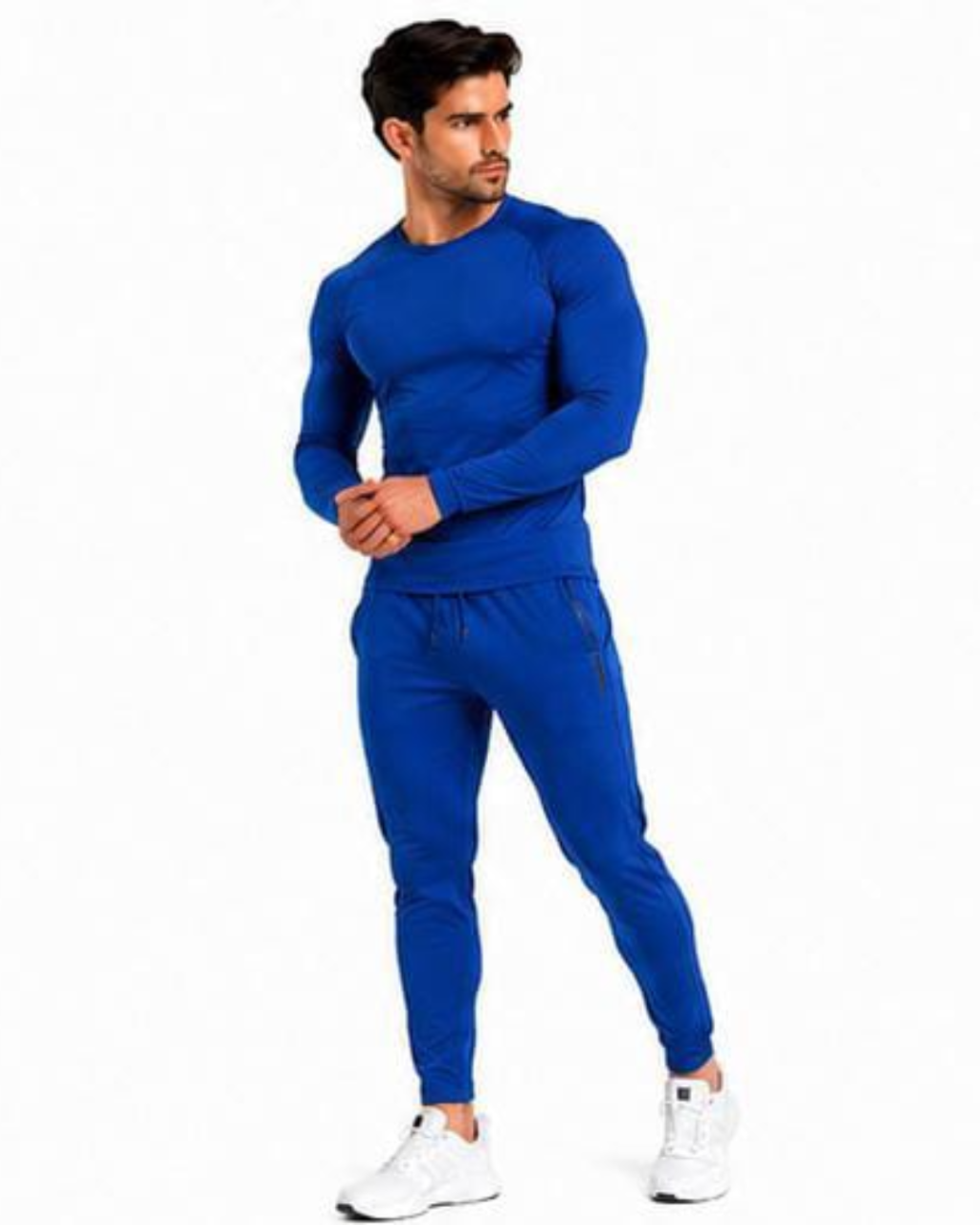 A man modeling a matching royal blue long-sleeve athletic top and jogger pants set, paired with white sneakers, against a plain white background.