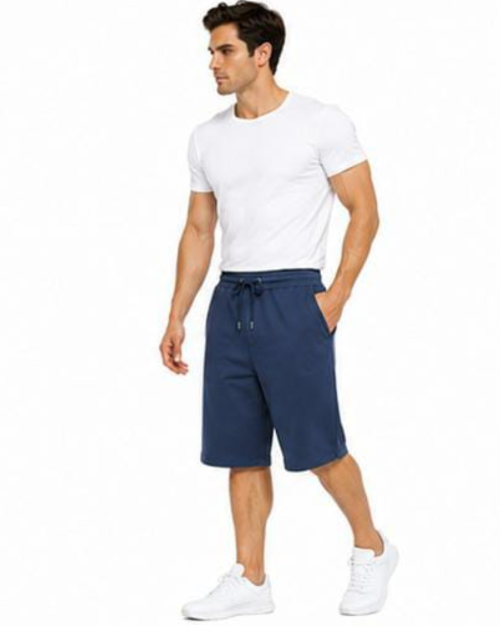 A man wearing a white crew-neck t-shirt, navy blue drawstring shorts, and white sneakers, standing against a plain white background.