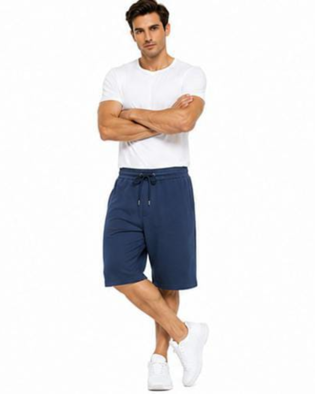 A man modeling navy blue drawstring shorts, paired with a white t-shirt and white sneakers, standing against a solid white background.