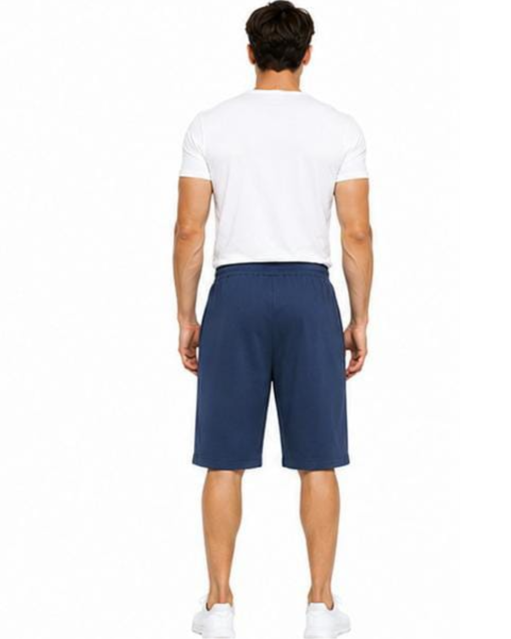 A man viewed from the back wearing a white t-shirt, navy blue athletic shorts, and white sneakers against a plain white background.