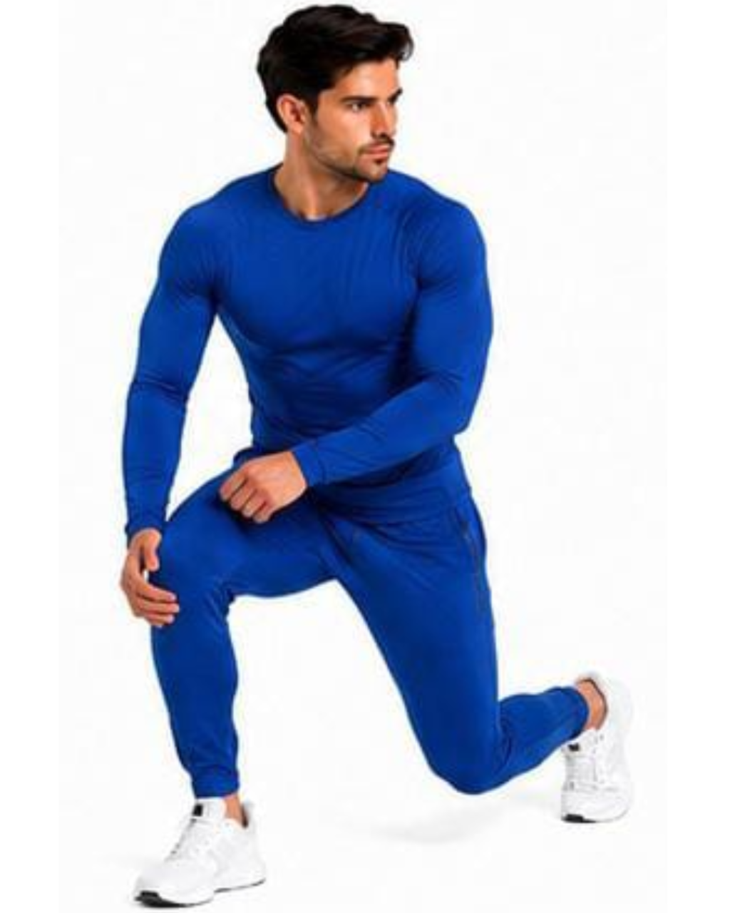 A man wearing a matching royal blue long-sleeve athletic top and jogger pants set, posed in a lunge stance against a plain white background.