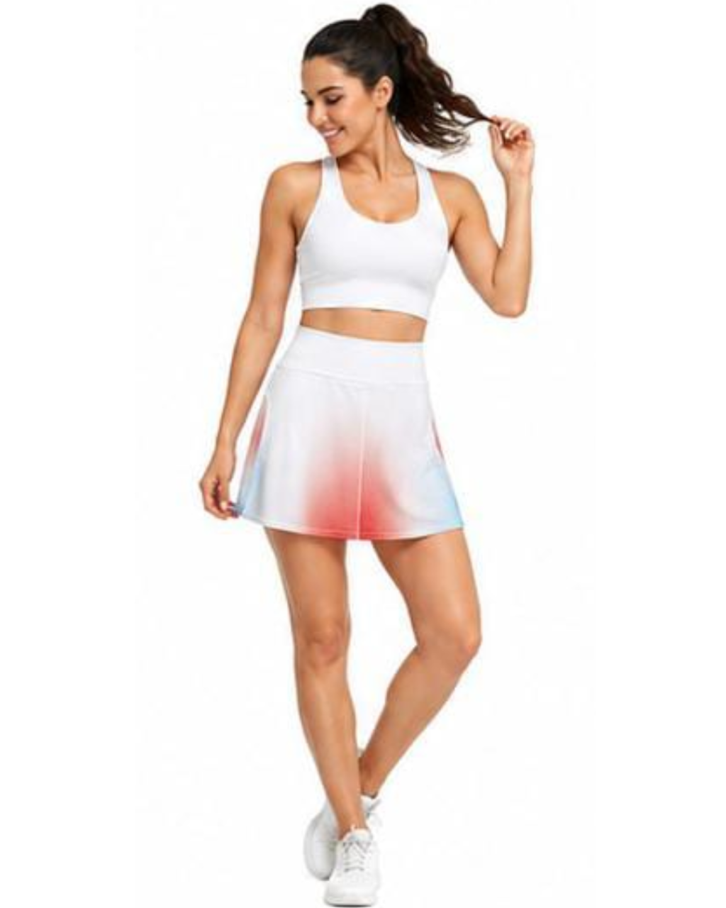 A woman modeling a white sports bra and a white athletic tennis skirt with a pink and blue ombre gradient at the hem, set against a plain white background.