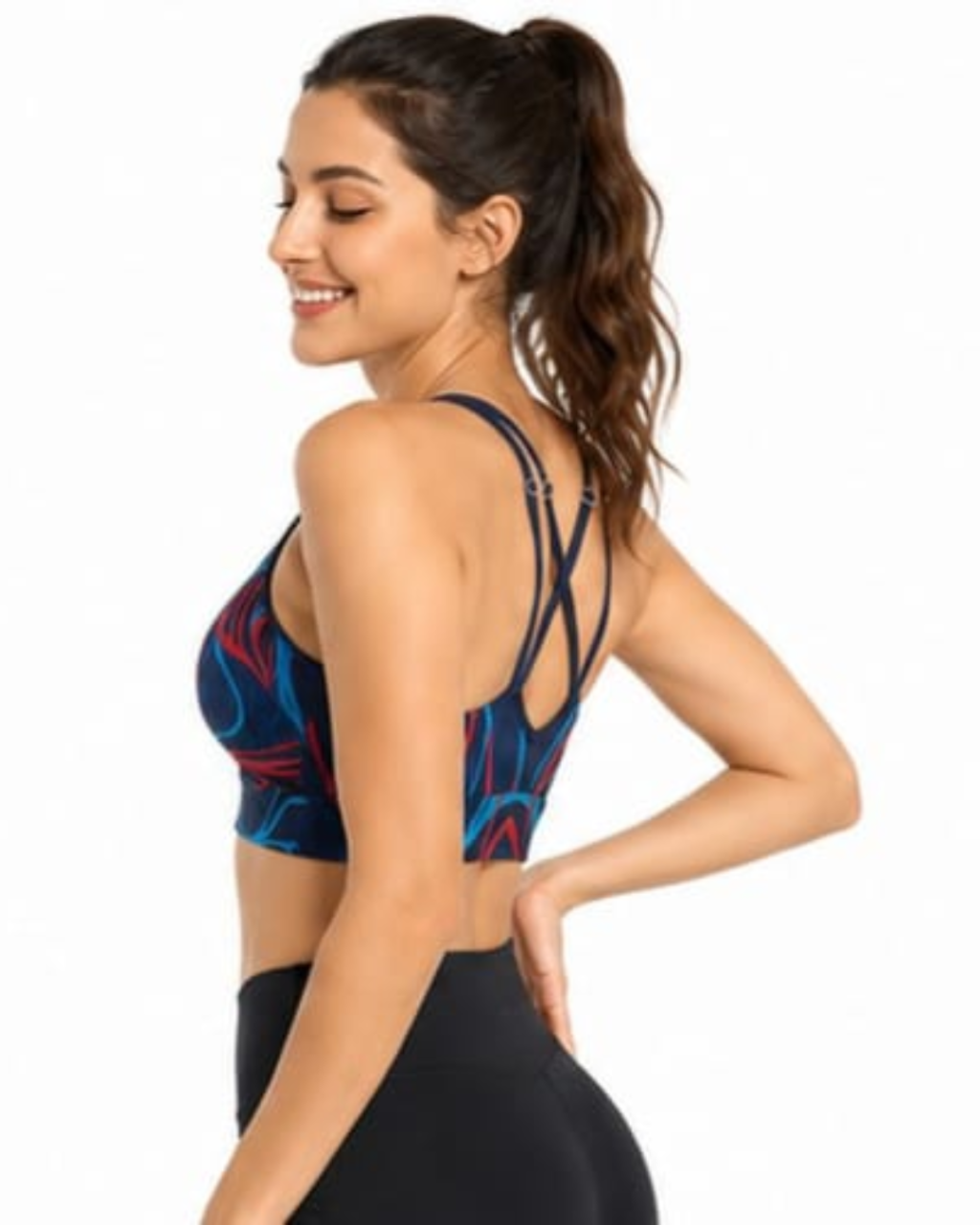 A woman wearing a sports bra with a blue, red, and black abstract pattern, shown from a side-back angle against a plain white background.