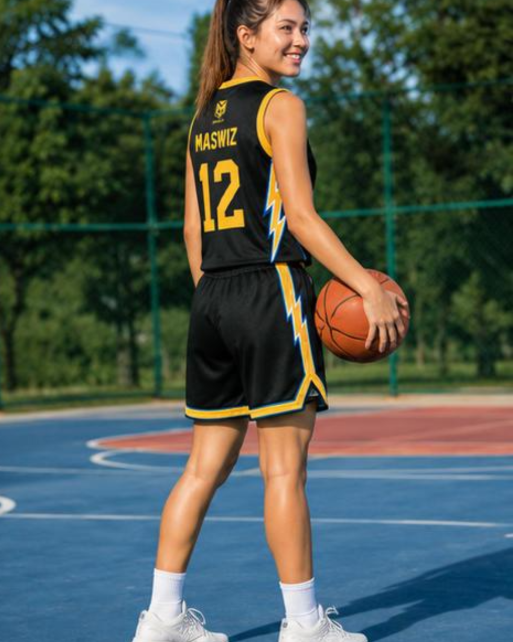 Person in a basketball uniform holding a ball on an outdoor court