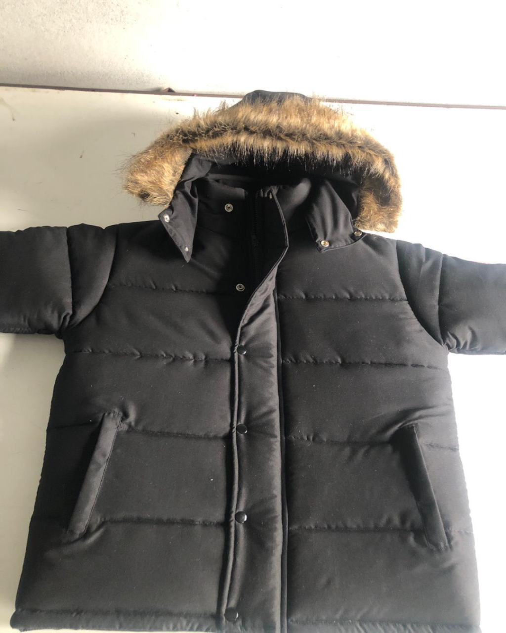 Black winter coat with fur hood on a white background