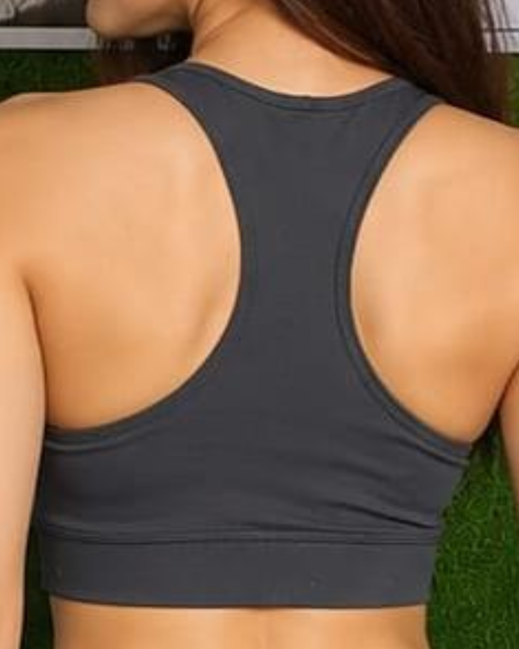 Person wearing a dark gray sports bra with a blurred background