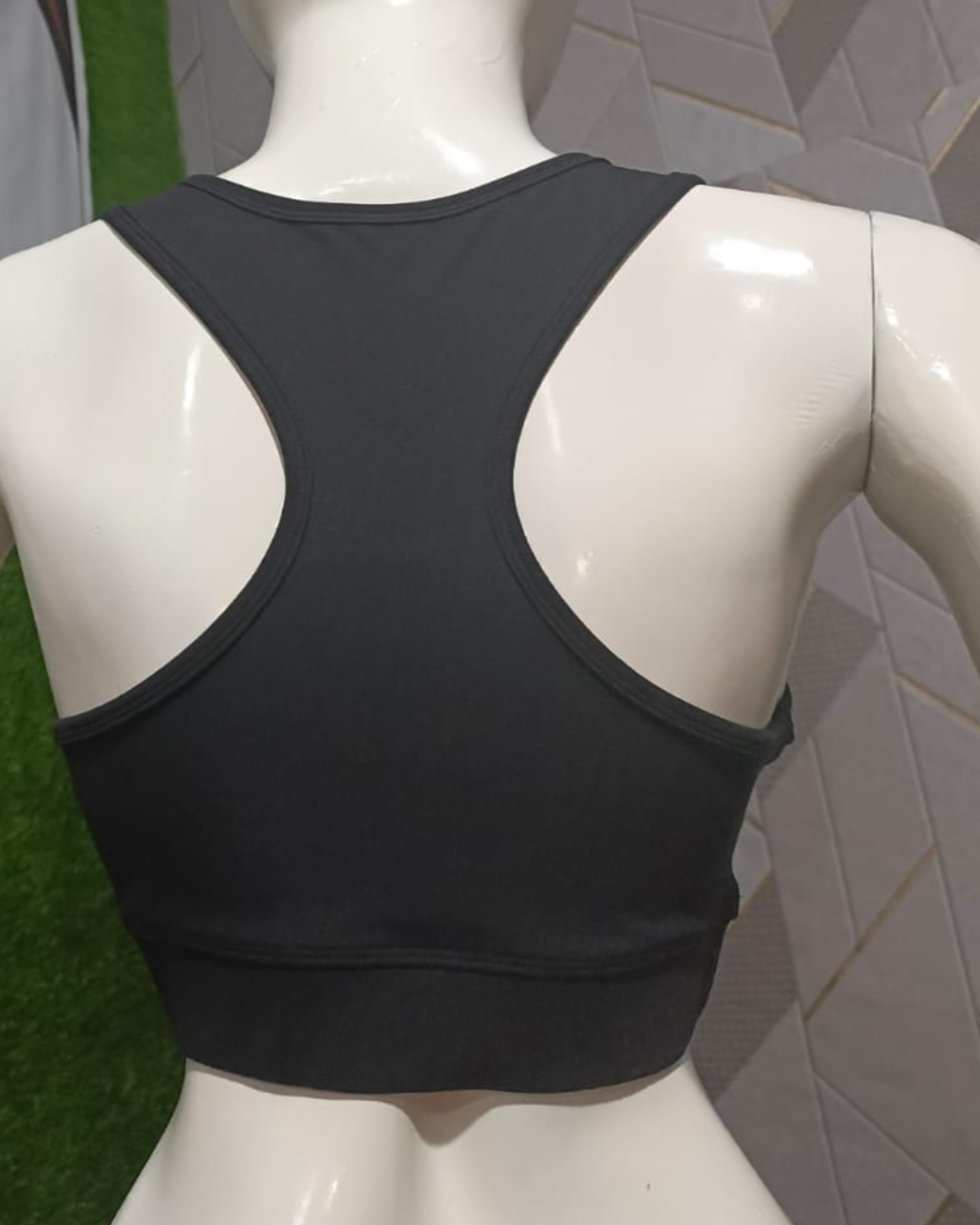 Black sports bra on a mannequin against a neutral background