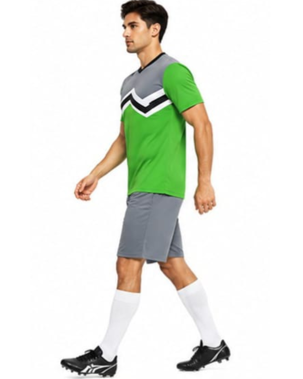 A man modeling a green and gray athletic soccer jersey with a black and white chevron pattern on the chest, paired with gray shorts, white socks, and black cleats, set against a plain white background.