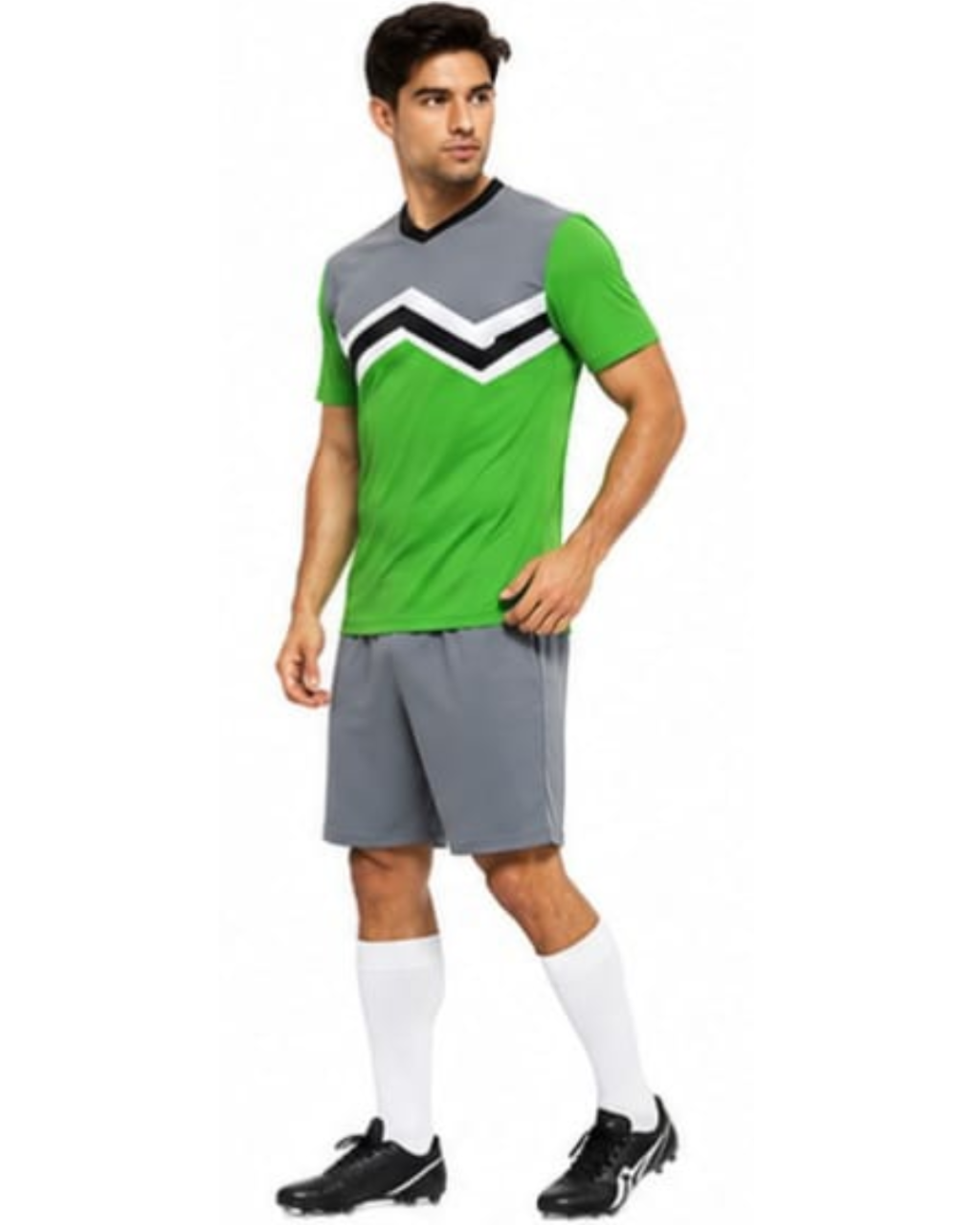 A man modeling a green and gray soccer jersey with a black and white chevron pattern, paired with gray shorts, white socks, and black cleats, against a plain white background.