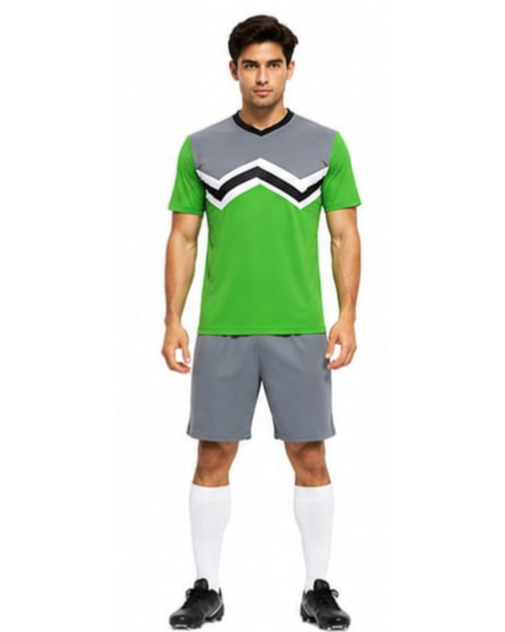 A man modeling a green and gray soccer jersey with a black and white chevron pattern on the chest, paired with gray shorts, white socks, and black cleats, against a plain white background.