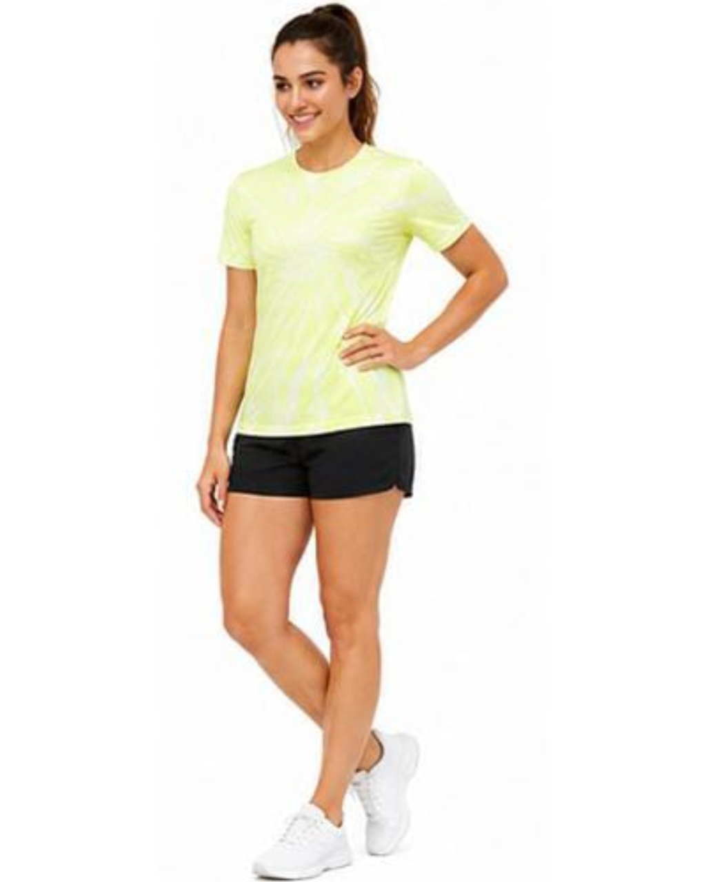 A woman modeling a short-sleeve athletic t-shirt in neon yellow-green with a subtle diagonal pattern, paired with black athletic shorts and white sneakers, against a plain white background.