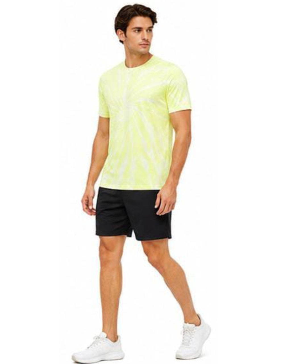 A man modeling a neon yellow-green tie-dye t-shirt with black athletic shorts and white sneakers, set against a plain white background.