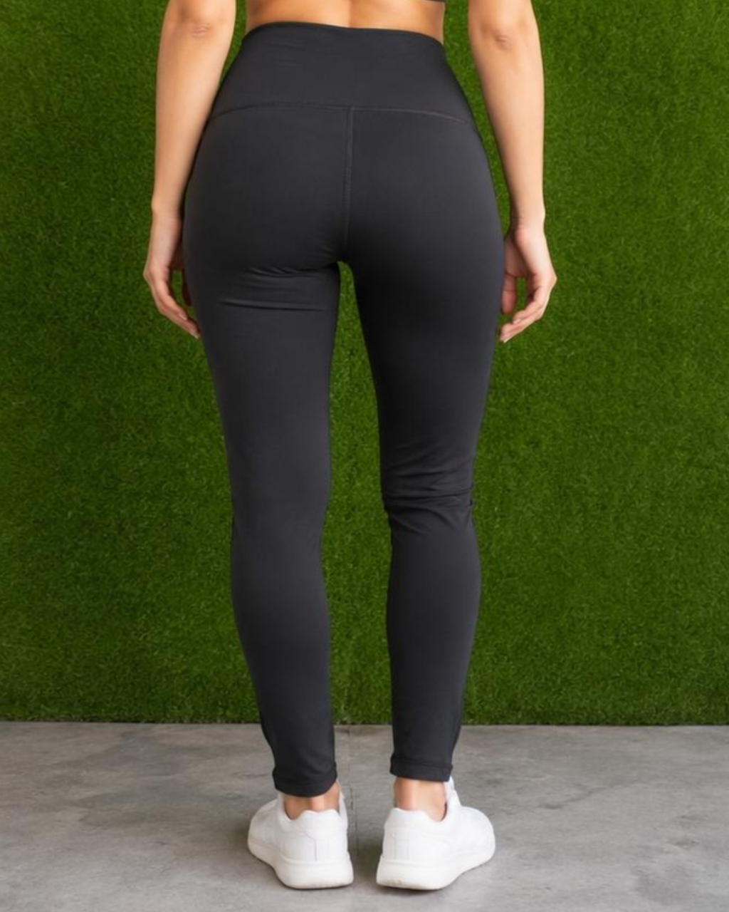 Person wearing black leggings with a green grass background