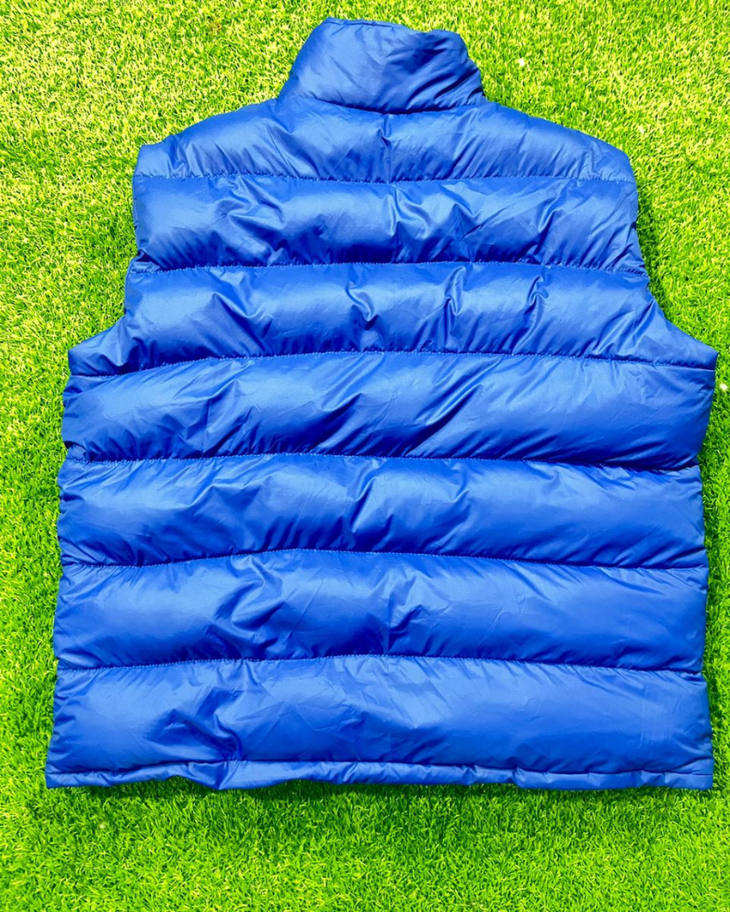 Blue puffer vest on a green grass background MI-03