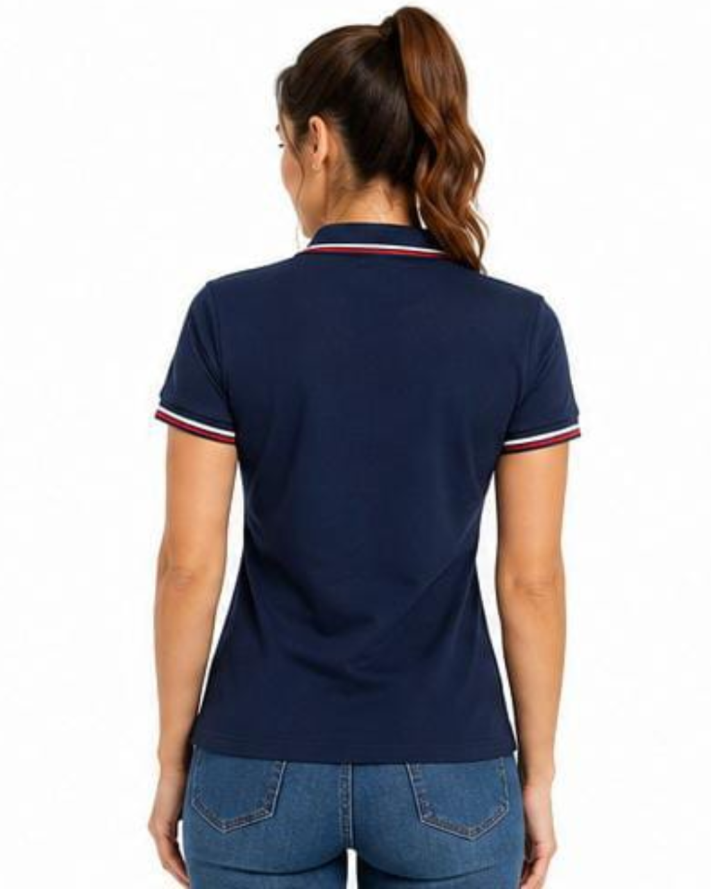 A woman viewed from the back wearing a navy blue short-sleeve polo shirt with white and red striped trim on the collar and sleeve cuffs, paired with blue jeans against a plain white background.