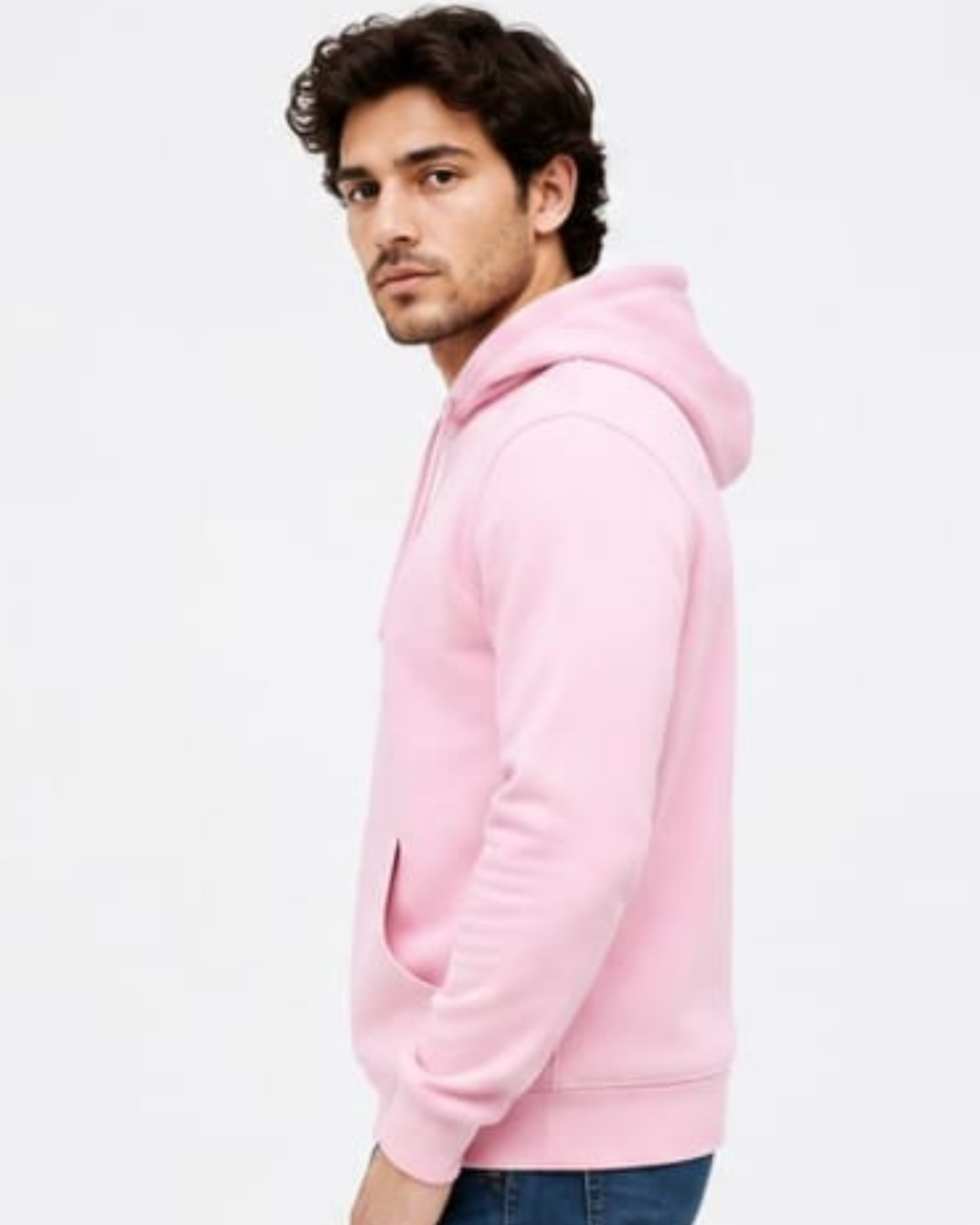 A man wearing a light pink pullover hoodie, shown from a side profile against a plain white studio background.