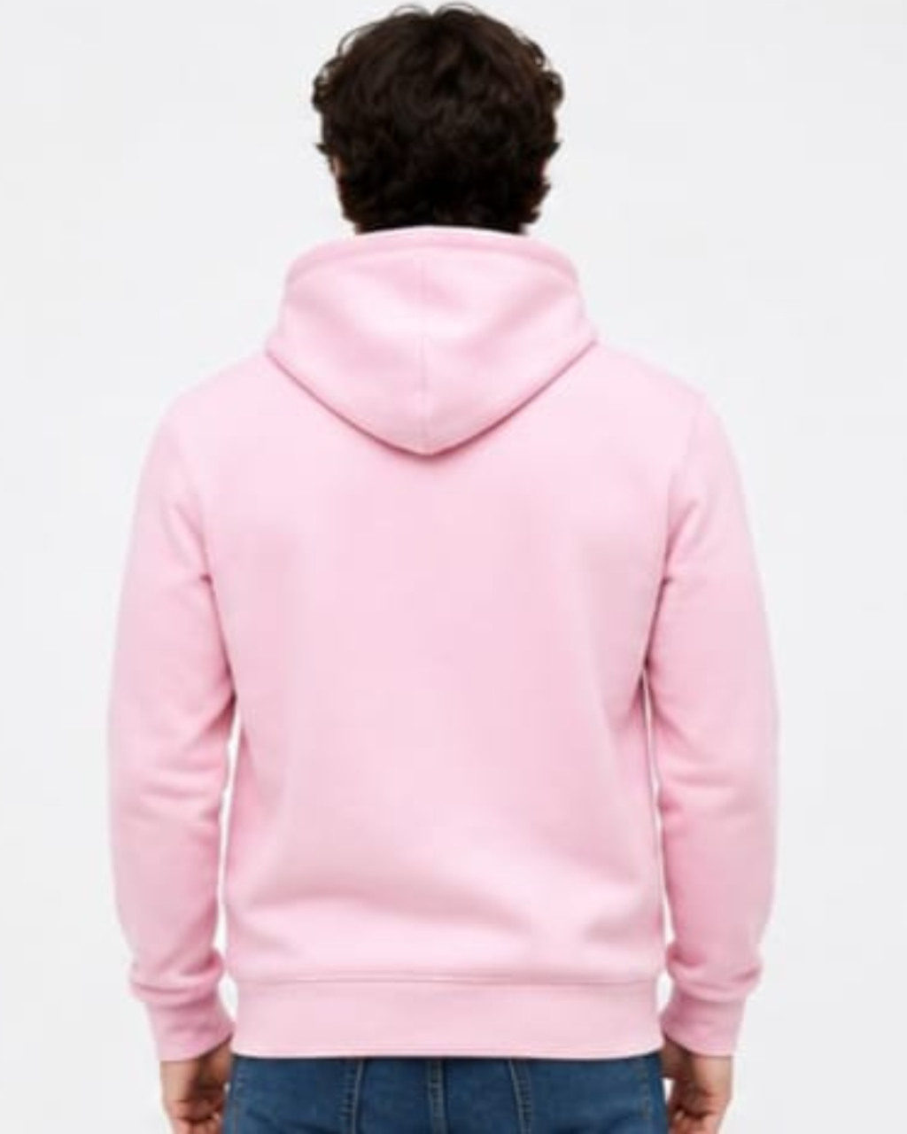 A person viewed from the back wearing a light pink pullover hoodie with blue jeans, set against a plain white studio background.