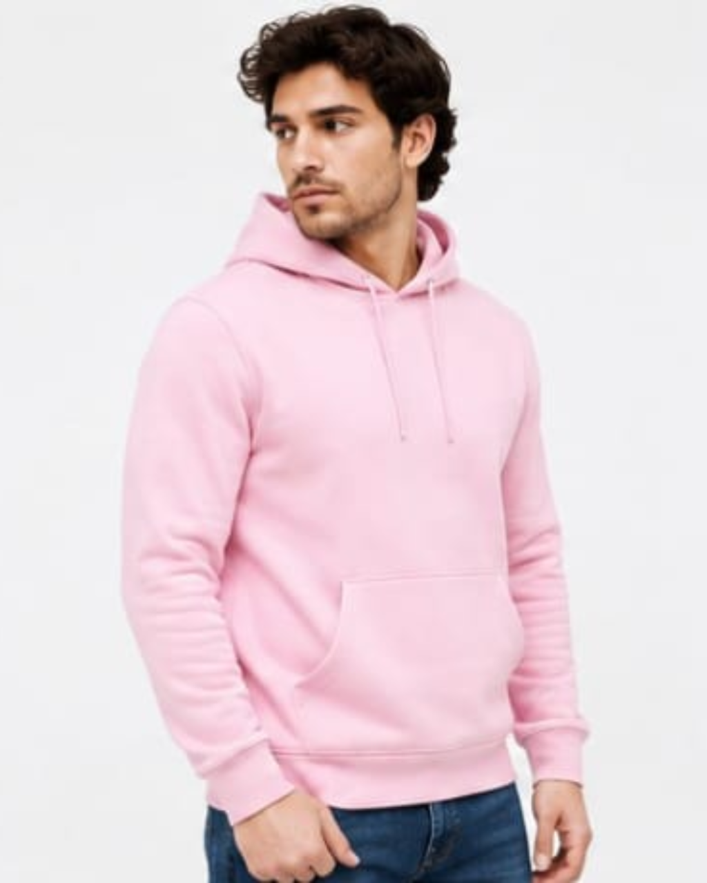 A man wearing a light pink pullover hoodie with a front kangaroo pocket and matching drawstrings, paired with blue jeans, against a plain white background.