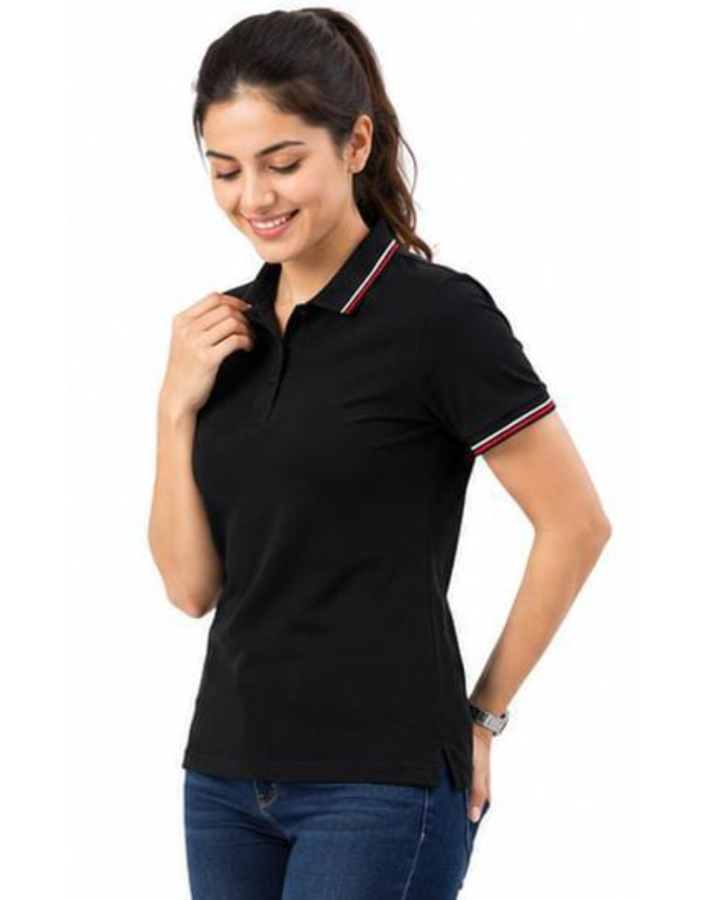 A woman wearing a black short-sleeve polo shirt with red and white striped trim on the collar and sleeve cuffs, paired with blue jeans, against a plain white background.