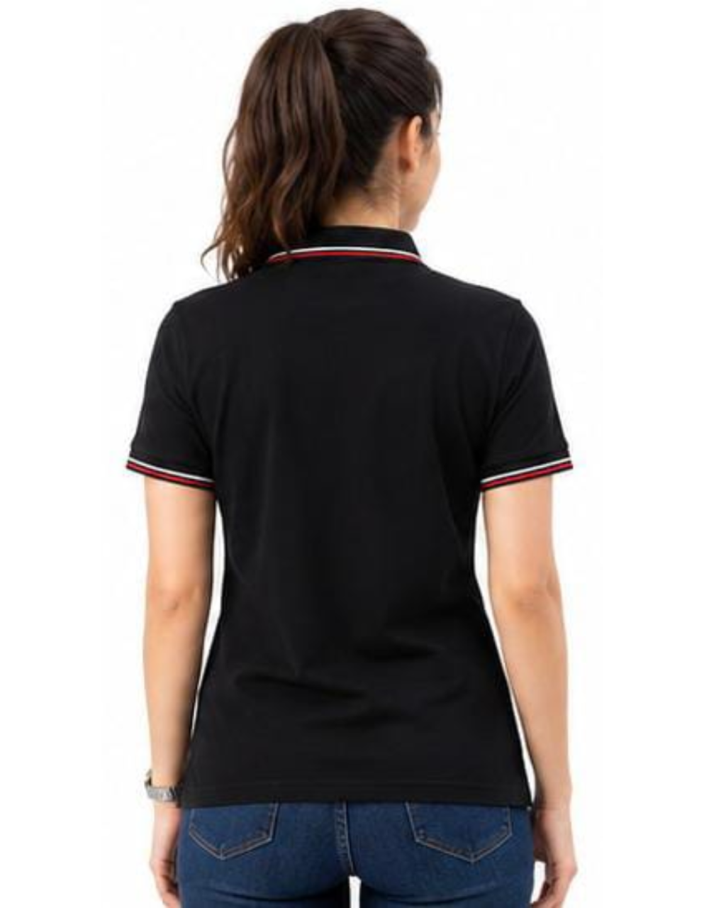 A woman viewed from the back wearing a black short-sleeve polo shirt with red and white striped trim on the collar and sleeve cuffs, paired with blue jeans against a plain white background.