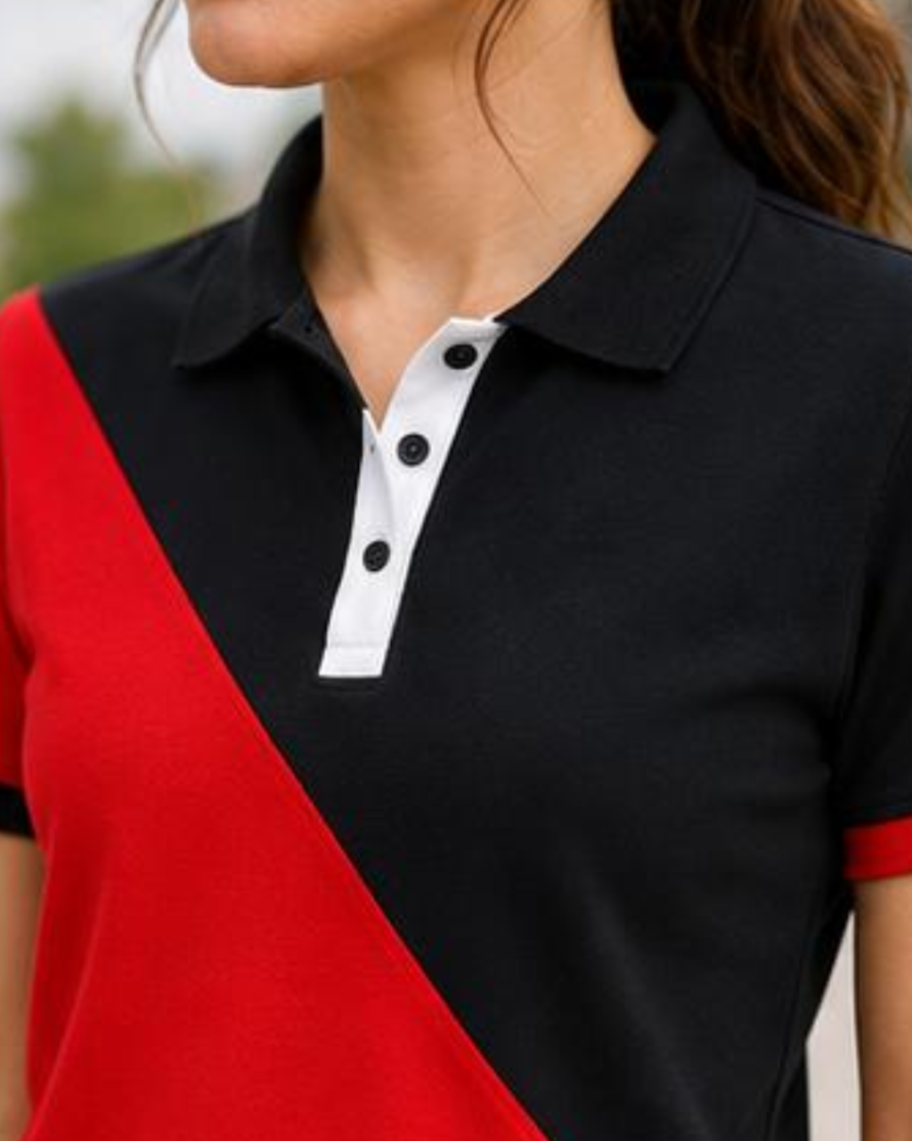 Close-up of a person wearing a black and red polo shirt with white buttons.