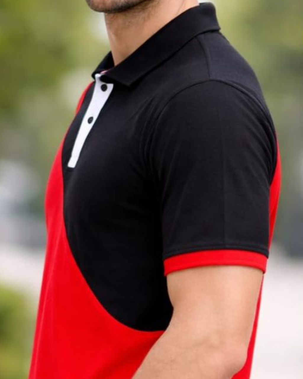 Person wearing a black and red polo shirt with blurred background