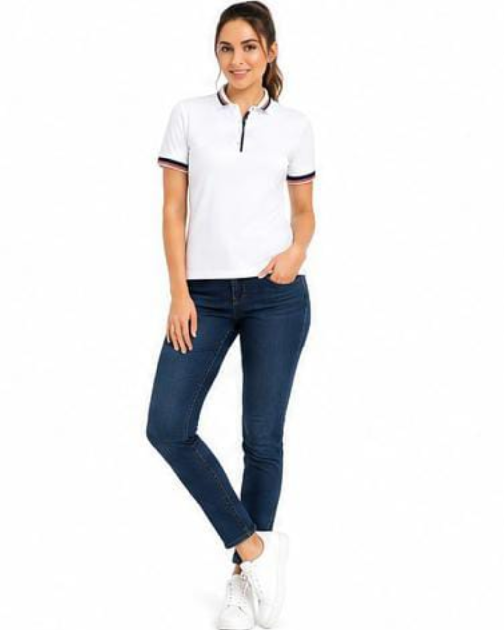 A woman modeling a white short-sleeve polo shirt with navy and red trim on the collar and sleeve cuffs, paired with dark blue skinny jeans and white sneakers, against a plain white background.