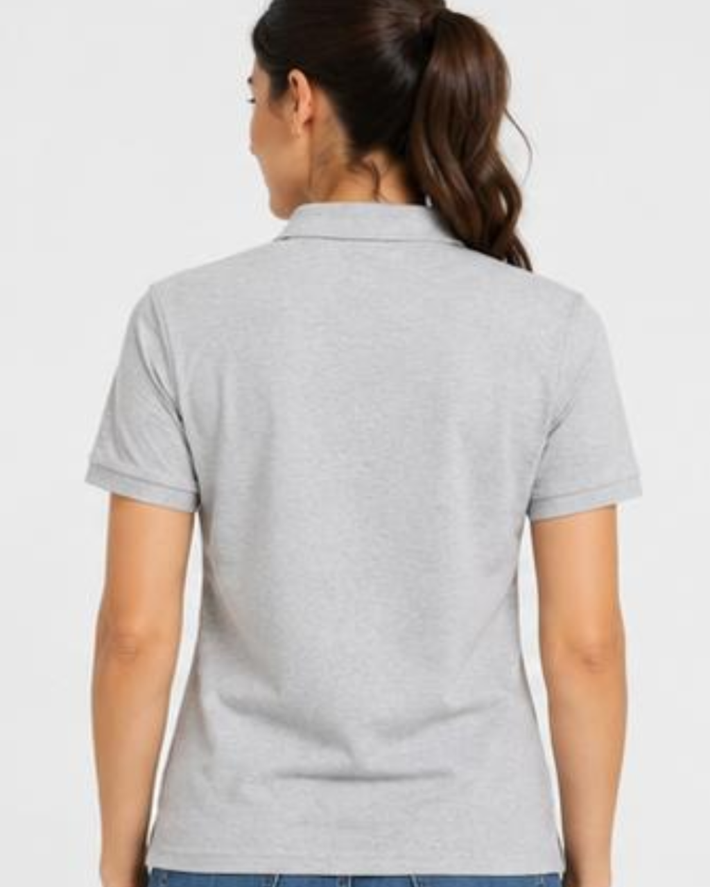 A woman viewed from the back wearing a light gray short-sleeve polo shirt, paired with blue jeans, against a plain light gray studio background.
