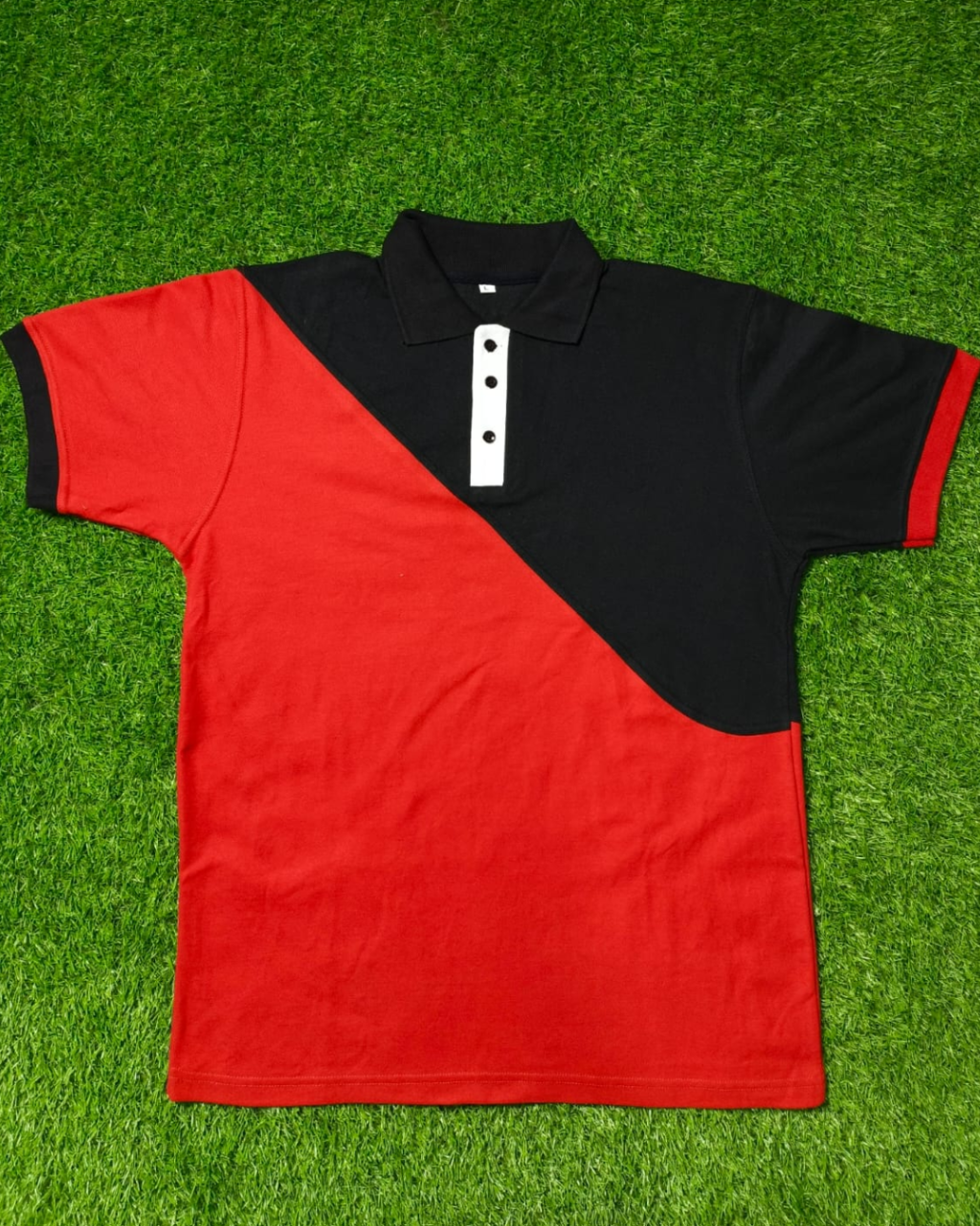 Red and black polo shirt on a green grass background