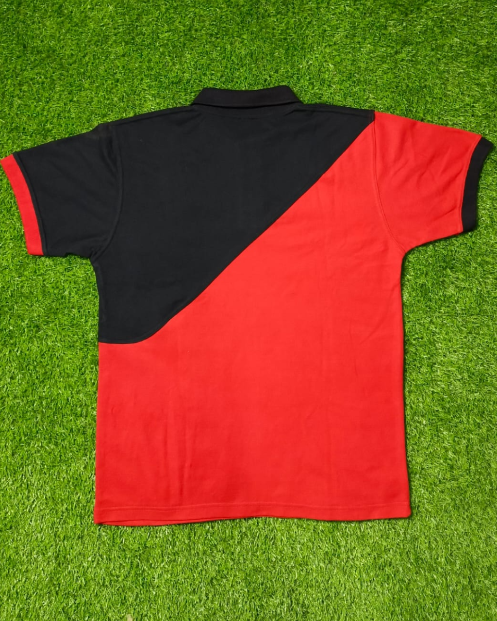 Red and black polo shirt on a grass background