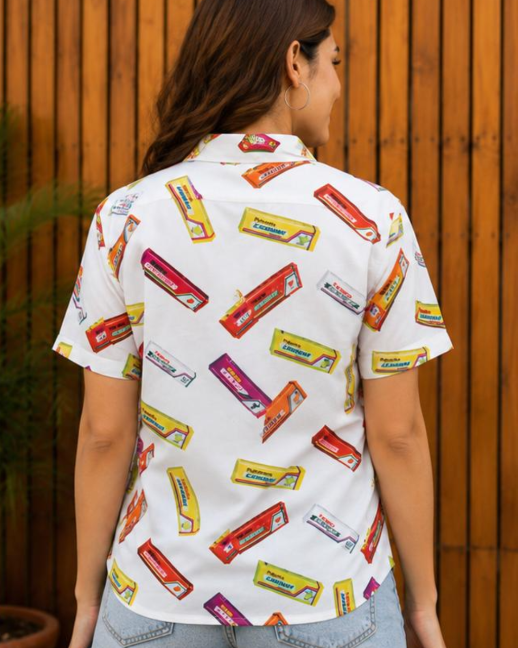 Person wearing a shirt with candy bar pattern against a wooden background
