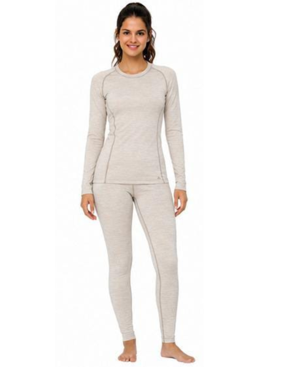 A woman modeling a light beige heathered two-piece athletic pajama set, consisting of a long-sleeve top and matching leggings, against a plain white background.