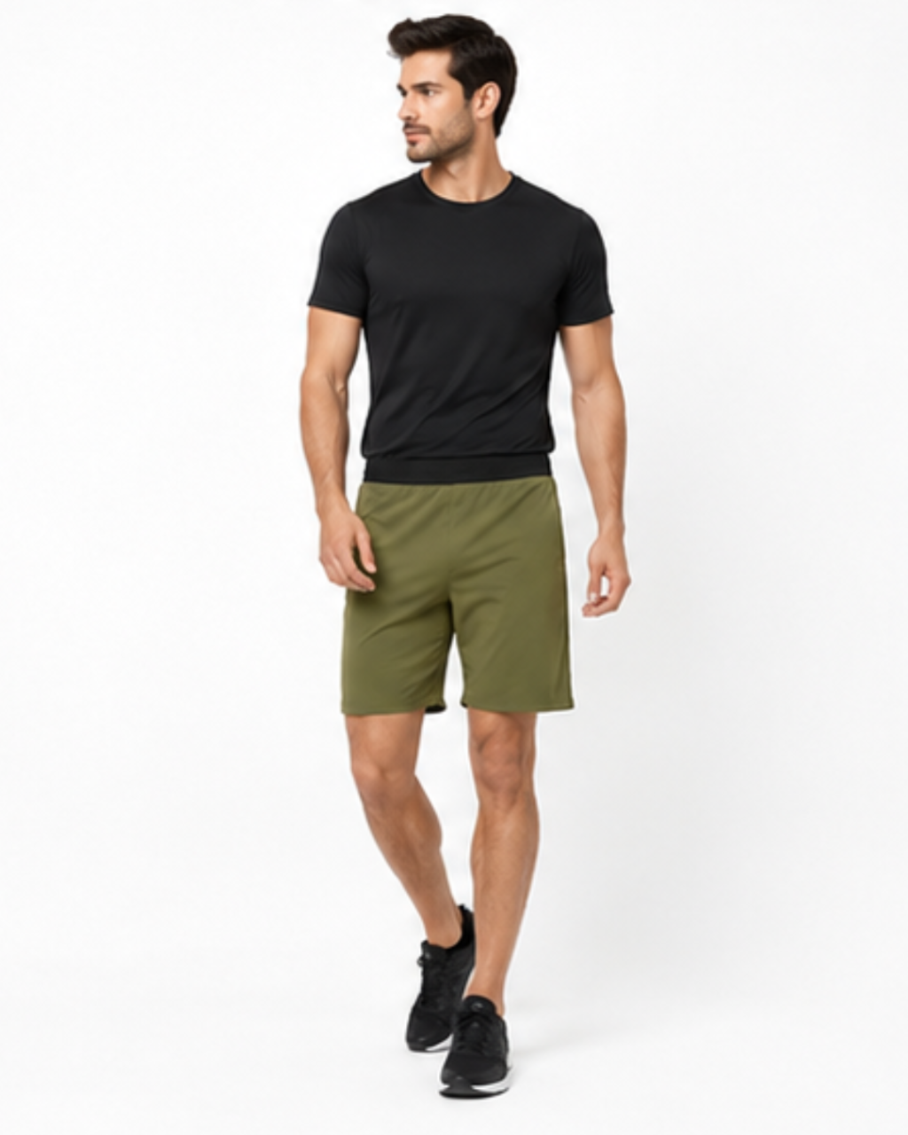 A man modeling a black short-sleeve crewneck t-shirt and olive green athletic shorts against a plain white studio background.