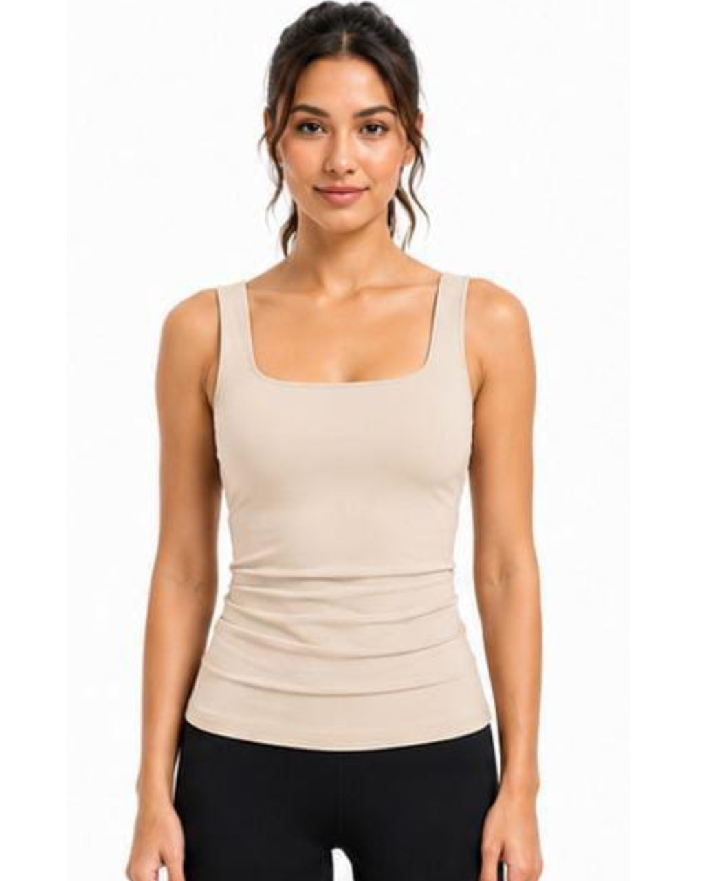 A woman modeling a beige scoop-neck tank top with a square neckline, paired with black leggings, against a plain white background.