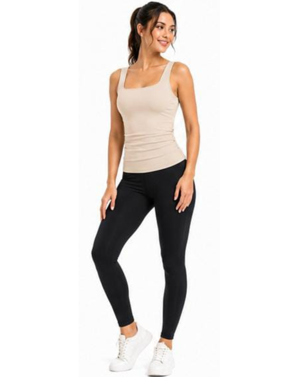 A woman modeling a beige ribbed tank top and black leggings with white sneakers, standing against a plain white background.