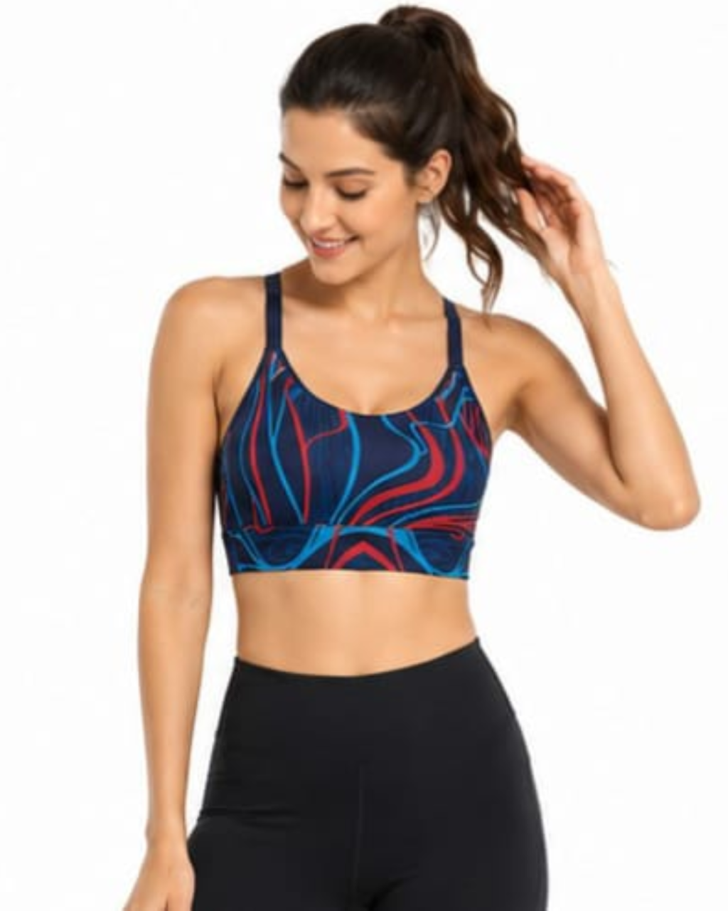 A woman wearing a navy blue sports bra with a red and light blue abstract swirl pattern, paired with black high-waisted leggings, against a plain white background.