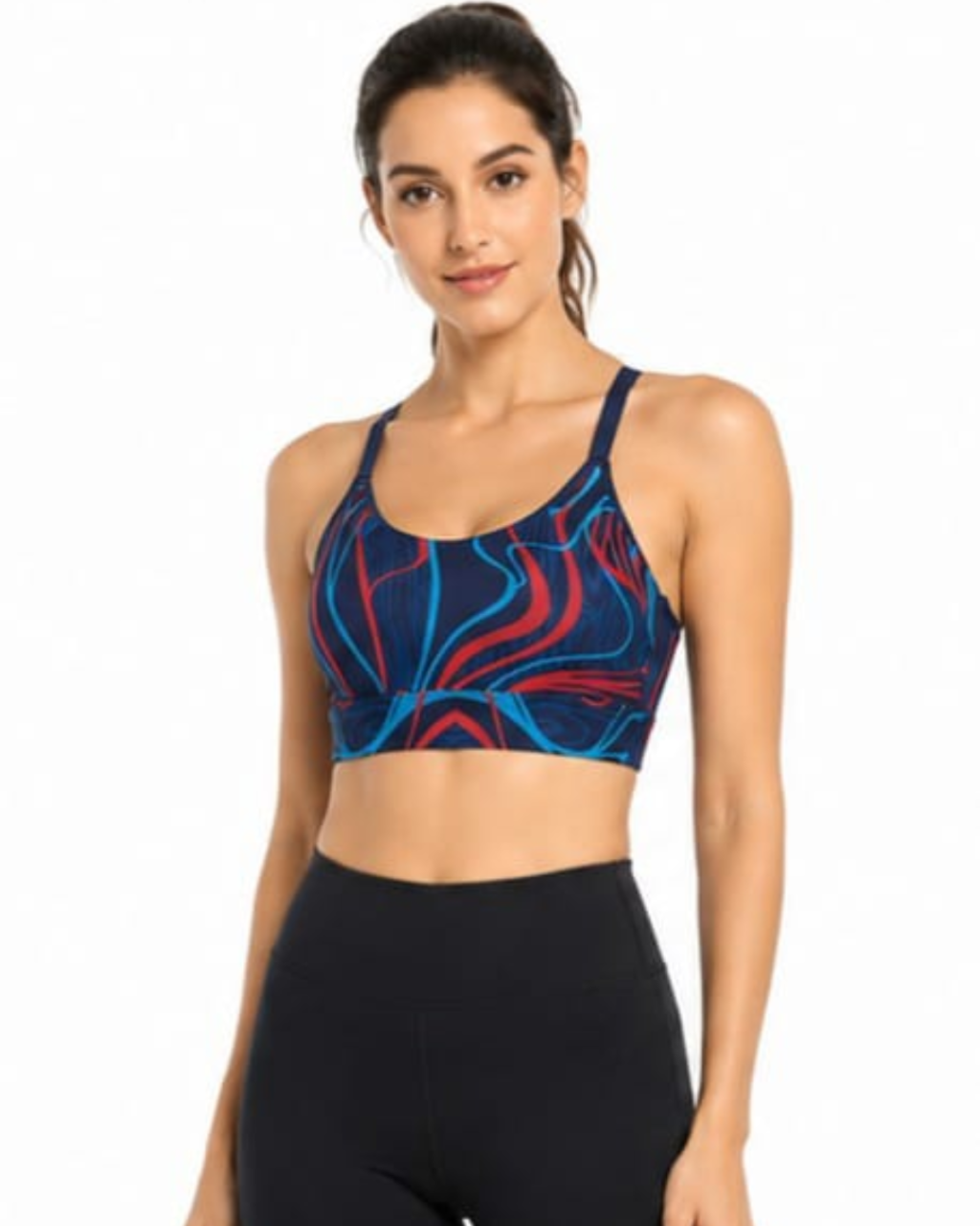 A woman modeling a sports bra with a navy blue base and abstract red and light blue wavy patterns, paired with black leggings, against a plain white background.