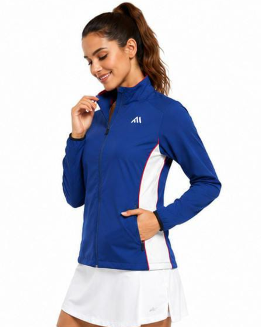 A woman wearing a royal blue athletic zip-up jacket with white side panels and a small white logo on the chest, paired with a white tennis skirt, against a plain white background.