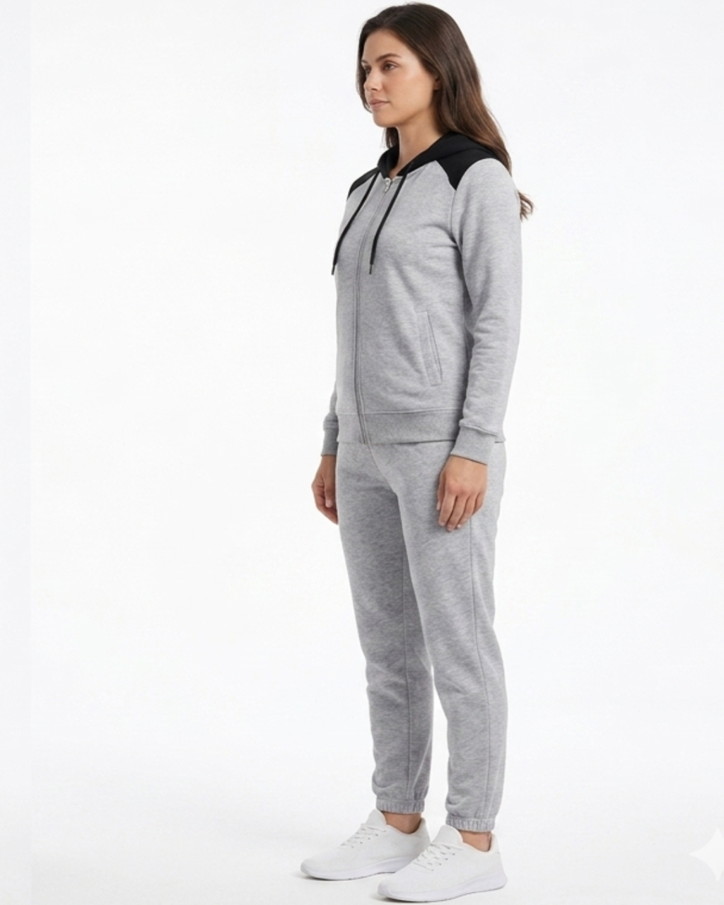 Woman wearing a gray tracksuit with black accents on a white background