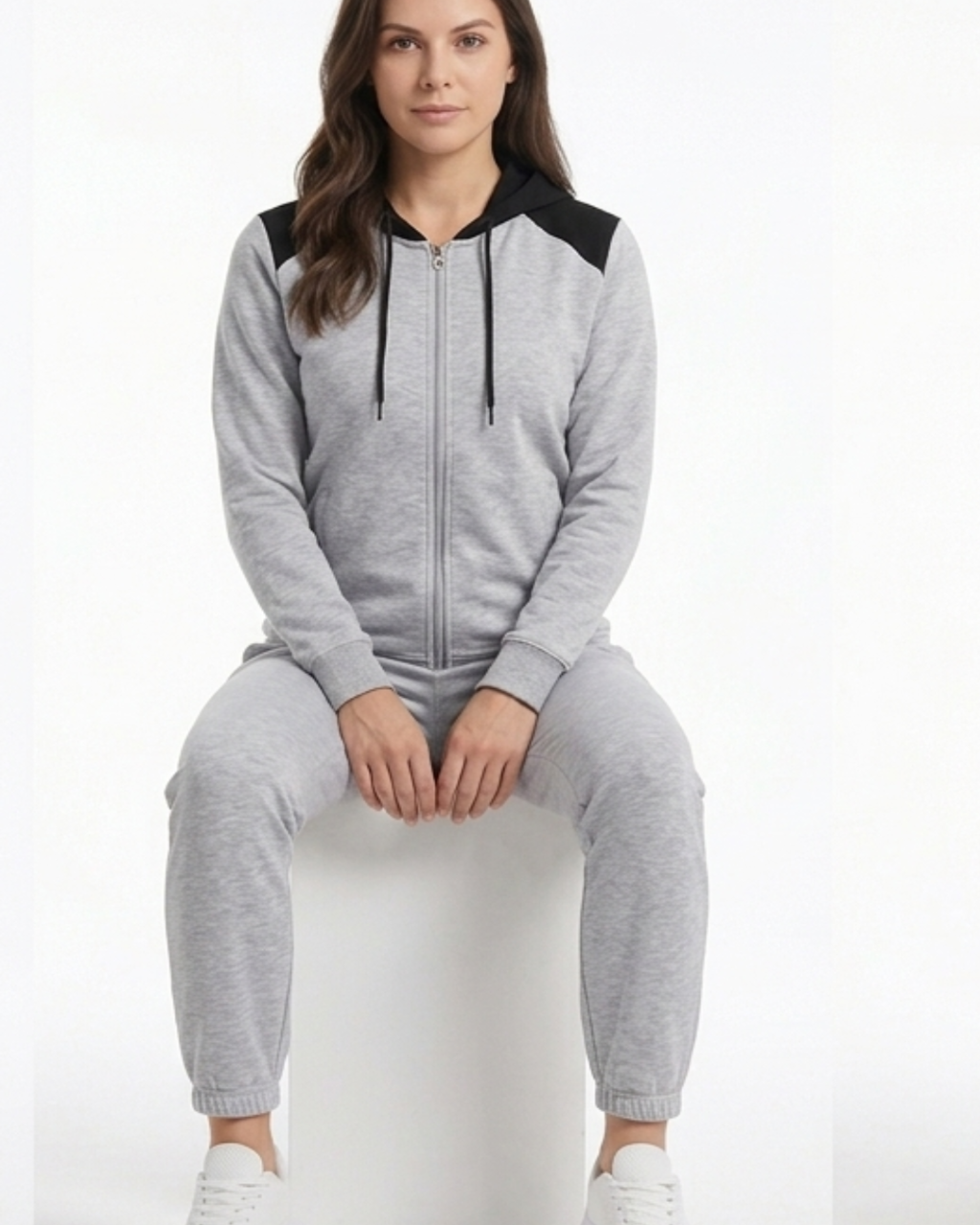 Woman wearing a gray onesie with black accents on a white background