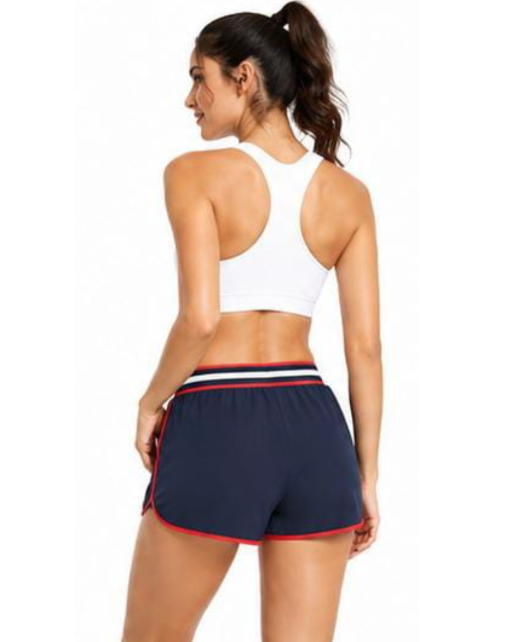 A woman shown from the back wearing a white sports bra and navy athletic shorts with red and white striped trim, against a plain white background.