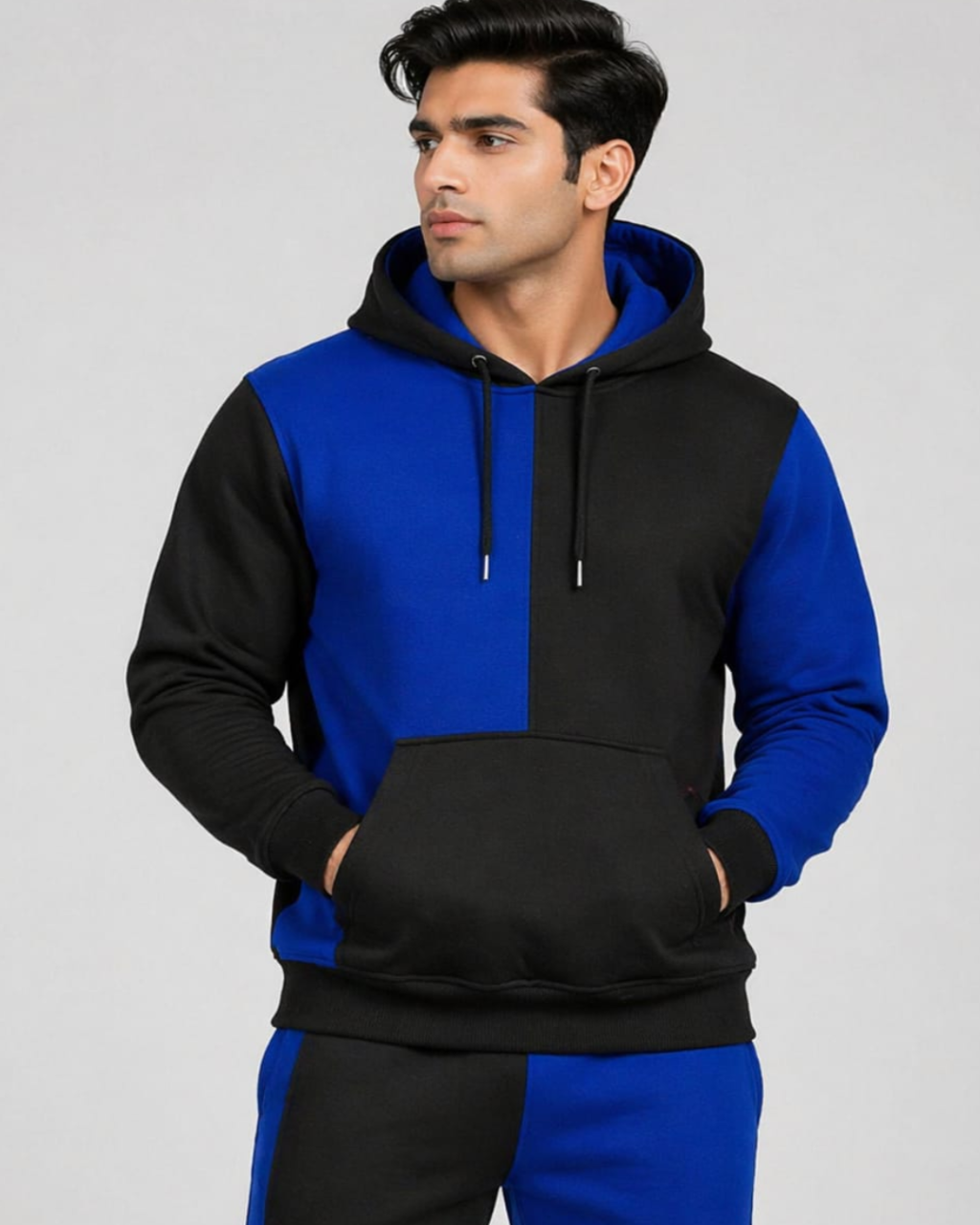 Man wearing a black and blue hoodie on a gray background