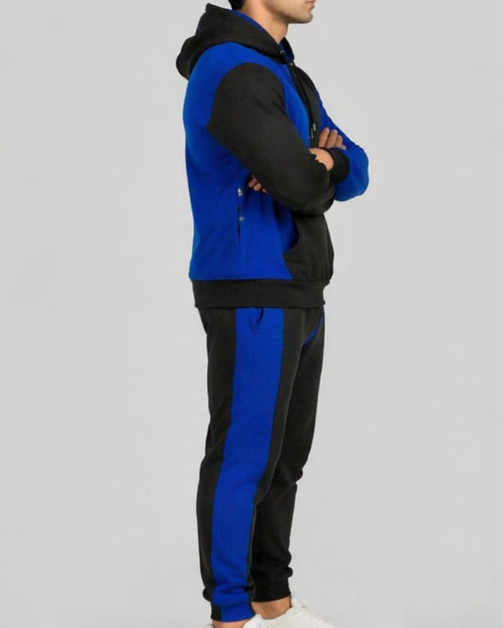 Person wearing a blue and black tracksuit on a gray background