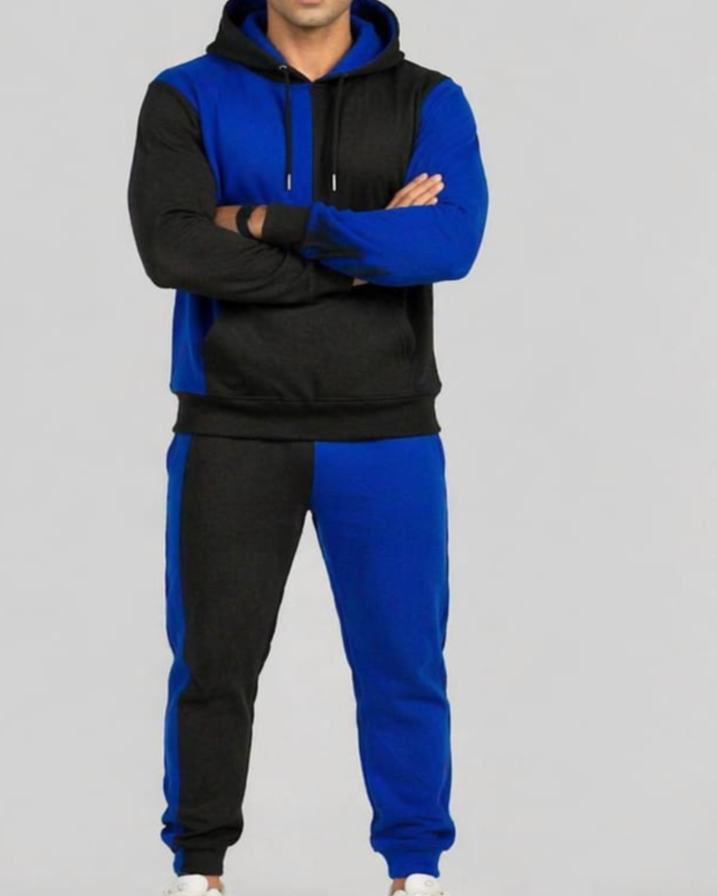 Person wearing a black and blue tracksuit on a gray background