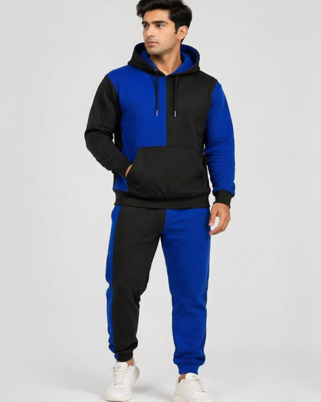 Man wearing a black and blue hoodie with matching pants on a white background