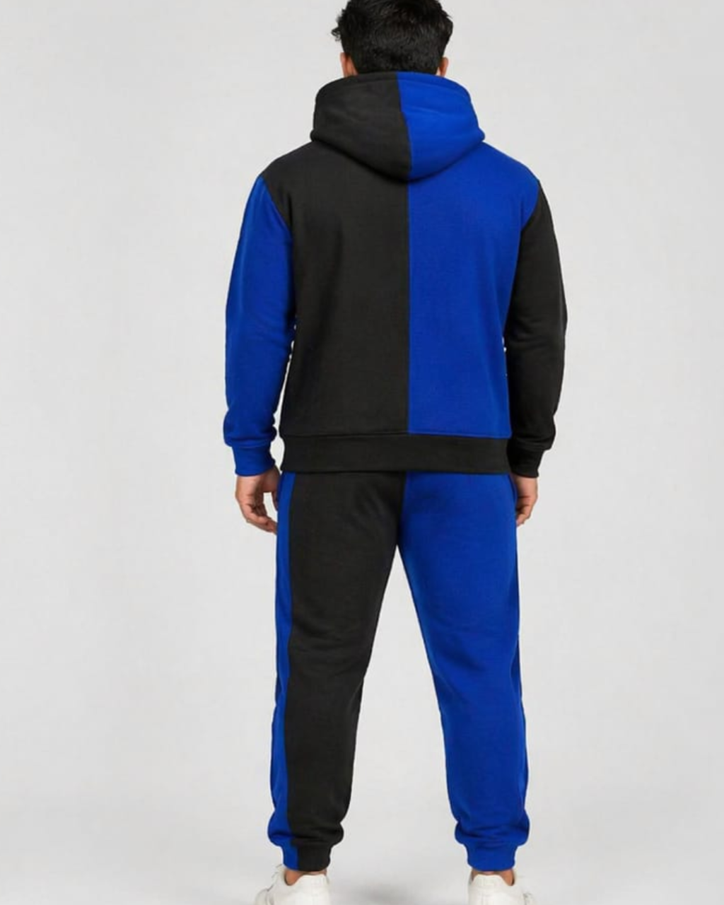Person wearing a black and blue tracksuit on a white background