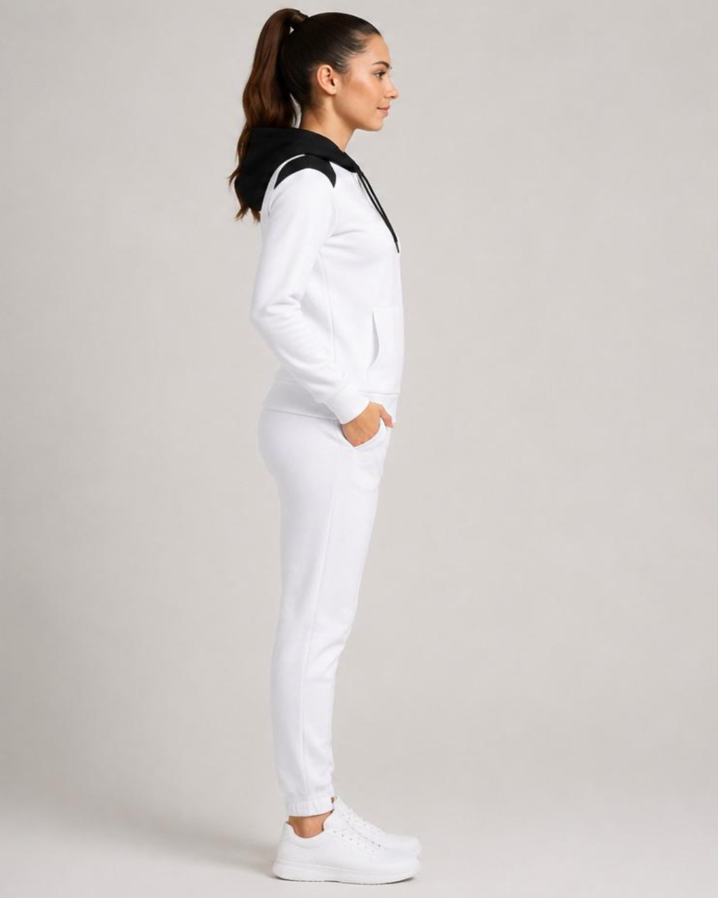 Woman wearing a white tracksuit on a plain background